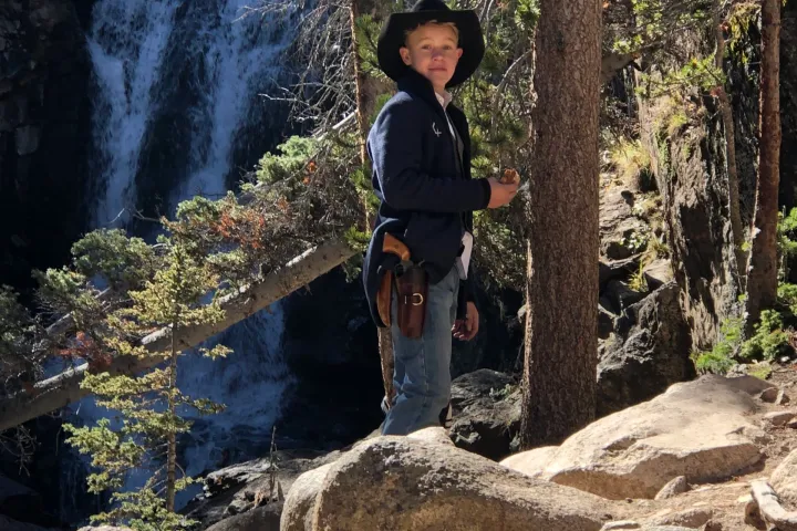 boy in front of a waterfall